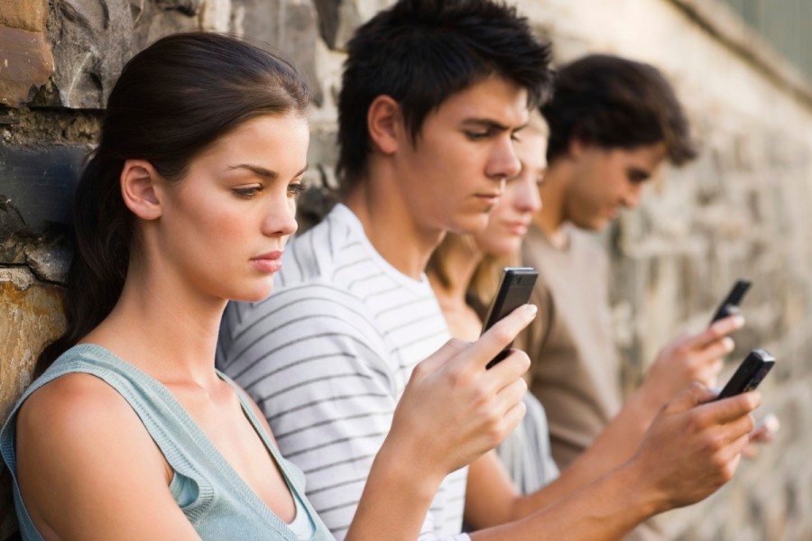 Closeup of young men and women holding cellphone